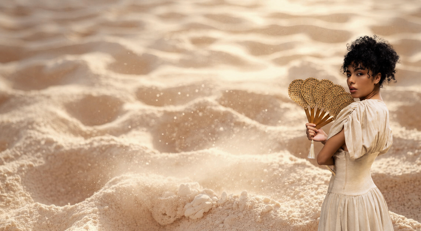 Woman holding natural fiber fans on the beach, Verde Mar resortwear collection